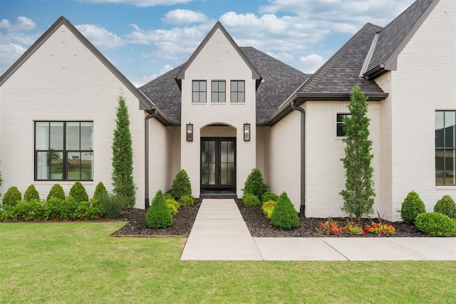 15012 Annecy Blvd, Oklahoma City, OK 73142 - view of front facade featuring roof with shingles, a front yard, french doors, and brick siding