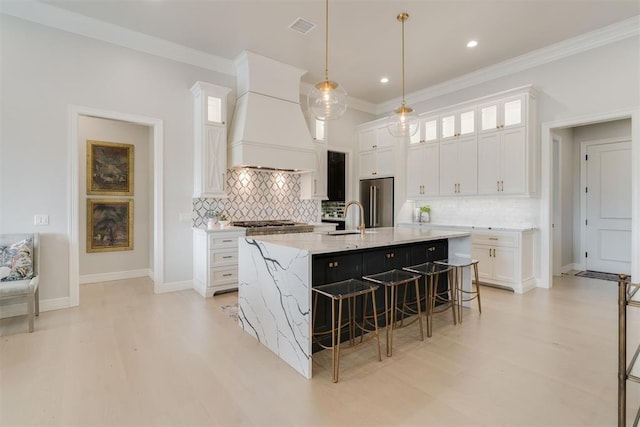 15012 Annecy Blvd, Oklahoma City, OK 73142 - kitchen featuring high end fridge, custom range hood, a kitchen bar, white cabinetry, and ornamental molding