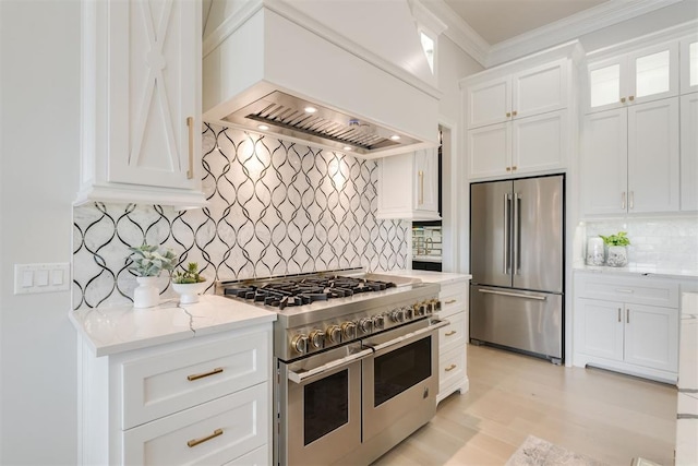 15012 Annecy Blvd, Oklahoma City, OK 73142 - kitchen with high quality appliances, ornamental molding, backsplash, white cabinetry, and light stone countertops