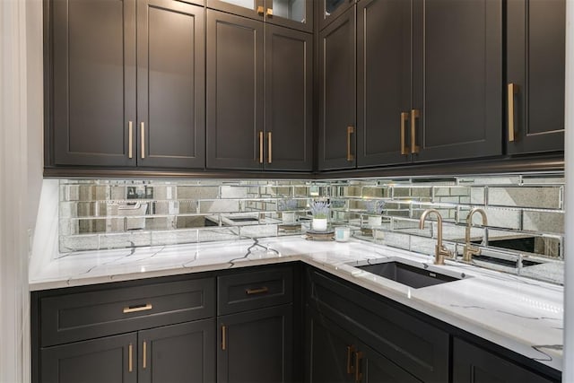 15012 Annecy Blvd, Oklahoma City, OK 73142 - kitchen featuring a sink, light stone countertops, glass insert cabinets, and tasteful backsplash