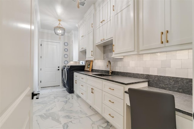 15012 Annecy Blvd, Oklahoma City, OK 73142 - kitchen featuring washer and clothes dryer, a sink, dark countertops, light marble finish flooring, and white cabinets
