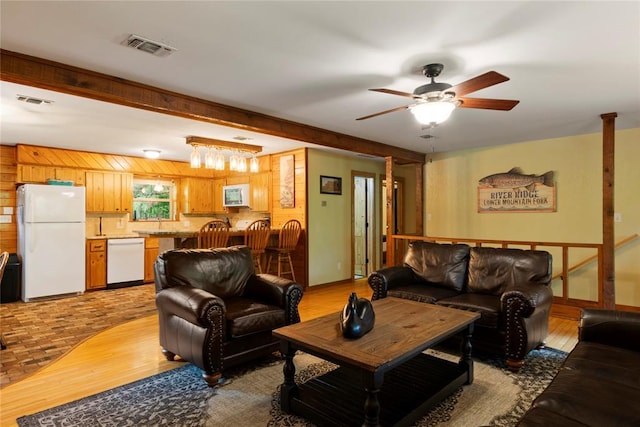 868 Red Fox Rd, Broken Bow, OK 74728 - living room with light wood-style floors, ceiling fan, and wooden walls