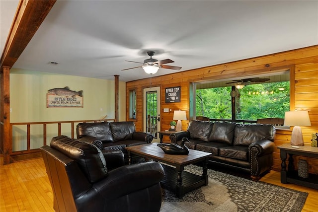 868 Red Fox Rd, Broken Bow, OK 74728 - living room featuring wood walls, a ceiling fan, and light wood-type flooring