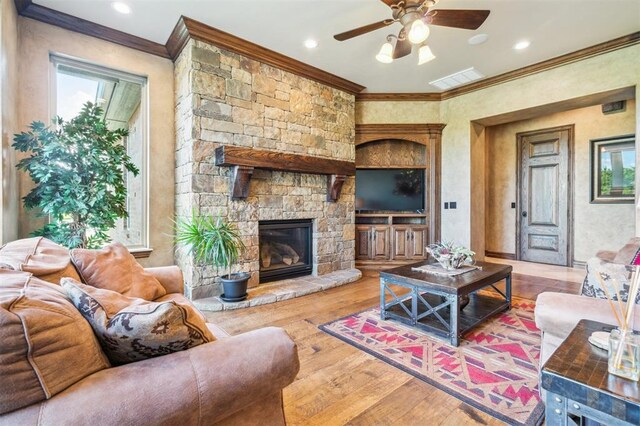 13600 W Britton Rd, Yukon, OK 73099 - living area featuring crown molding, a ceiling fan, wood finished floors, a stone fireplace, and recessed lighting