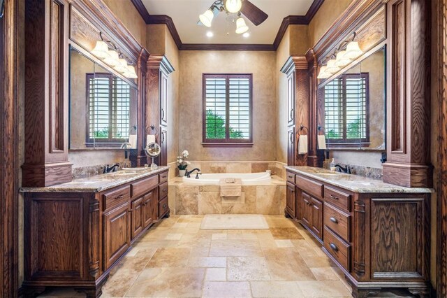 13600 W Britton Rd, Yukon, OK 73099 - full bathroom with stone tile floors, ornamental molding, ceiling fan, two vanities, and a garden tub