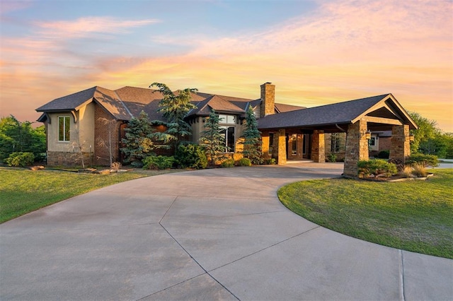 13600 W Britton Rd, Yukon, OK 73099 - view of front of house featuring stone siding, a front lawn, a chimney, and curved driveway