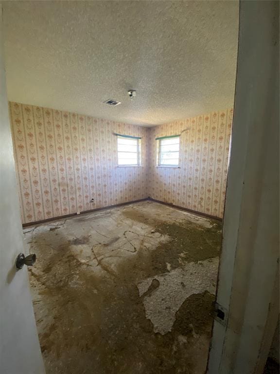 20403 E County Road 1567, Altus, OK 73521 - unfurnished room with wallpapered walls and a textured ceiling