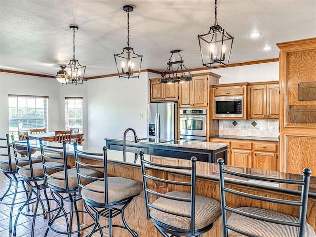 349412 E 840th Rd, Stroud, OK 74079 - kitchen with stainless steel appliances, a center island with sink, a chandelier, backsplash, and decorative light fixtures