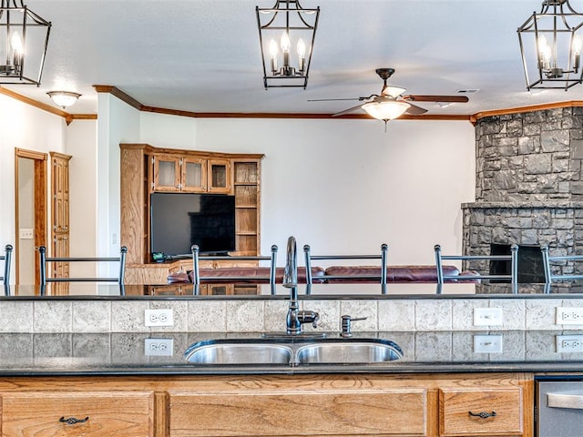 349412 E 840th Rd, Stroud, OK 74079 - kitchen with a sink, ceiling fan, crown molding, brown cabinets, and decorative light fixtures