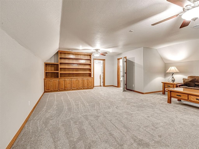 349412 E 840th Rd, Stroud, OK 74079 - unfurnished living room featuring ceiling fan, vaulted ceiling, a textured ceiling, light carpet, and baseboards
