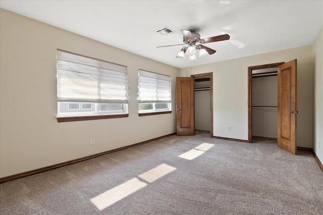 5839 Hefner Village Ct, Oklahoma City, OK 73162 - unfurnished bedroom featuring two closets, light carpet, baseboards, and ceiling fan