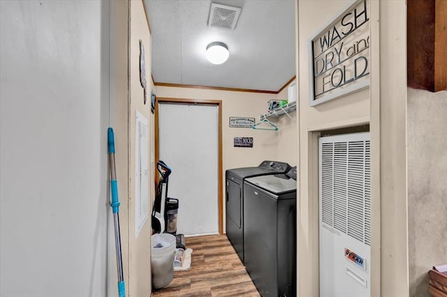 220 N Vernon Ave, Hinton, OK 73047 - washroom featuring a heating unit, separate washer and dryer, wood finished floors, and a textured ceiling
