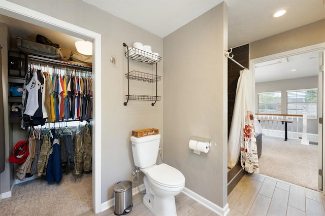2208 NW 16th St, Oklahoma City, OK 73107 - full bath with toilet, a shower with curtain, a walk in closet, baseboards, and wood finished floors