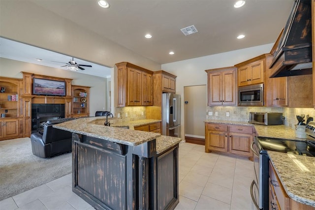239 Brandon Cir, Goldsby, OK 73093 - kitchen with stainless steel appliances, custom range hood, a peninsula, light stone countertops, and ceiling fan