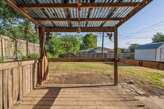 3701 NW 59th St, Oklahoma City, OK 73112 - wooden terrace featuring a storage unit and an outbuilding