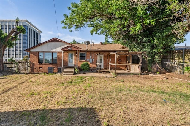 3701 NW 59th St, Oklahoma City, OK 73112 - rear view of property with brick siding, a deck, and central AC