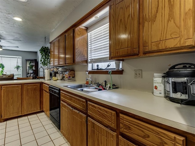 312 Carlsbad Ct, Yukon, OK 73099 - kitchen with black dishwasher, light countertops, a sink, and light tile patterned flooring