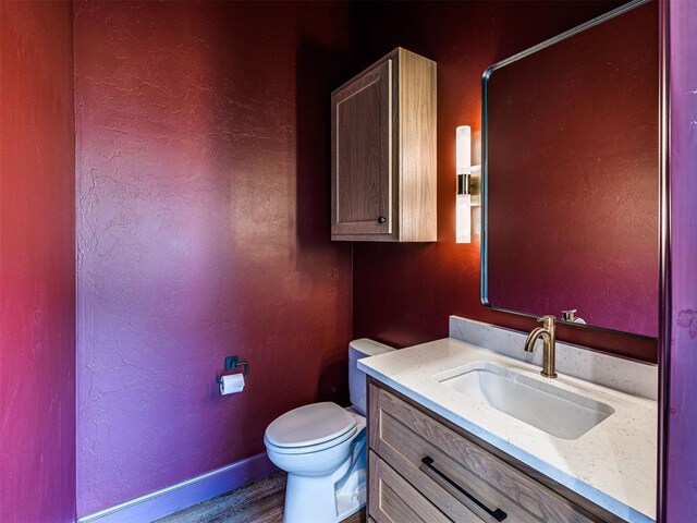 29612 Memory Ln, Norman, OK 73072 - half bath with toilet, vanity, wood finished floors, baseboards, and a textured wall