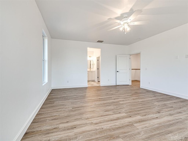 29612 Memory Ln, Norman, OK 73072 - unfurnished bedroom featuring light wood-style floors, baseboards, ensuite bathroom, and ceiling fan