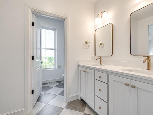 29612 Memory Ln, Norman, OK 73072 - bathroom featuring toilet, double vanity, and baseboards