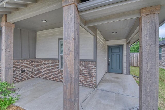 20101 Park Ln, Harrah, OK 73045 - property entrance featuring brick siding, a patio area, and board and batten siding