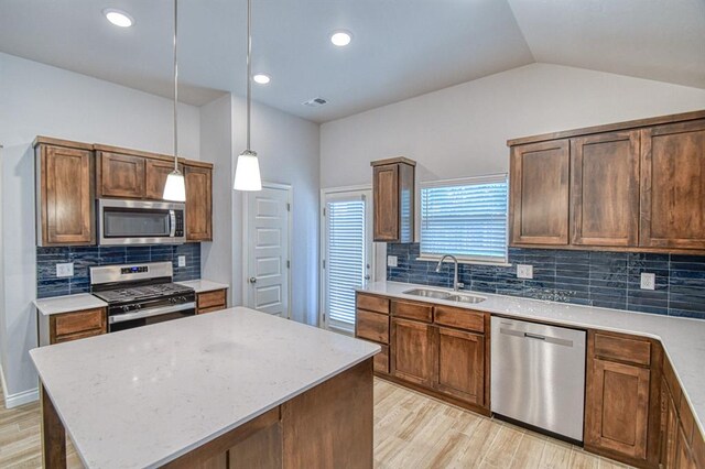 20101 Park Ln, Harrah, OK 73045 - kitchen featuring appliances with stainless steel finishes, a sink, light wood-style floors, decorative backsplash, and lofted ceiling