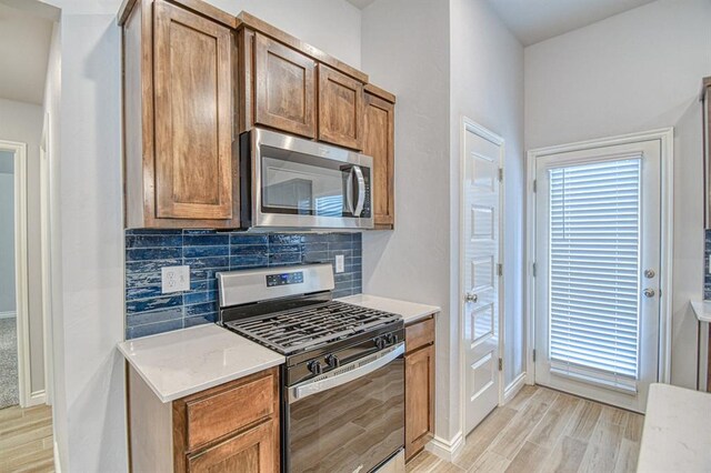 20101 Park Ln, Harrah, OK 73045 - kitchen featuring appliances with stainless steel finishes, light wood-type flooring, tasteful backsplash, and baseboards
