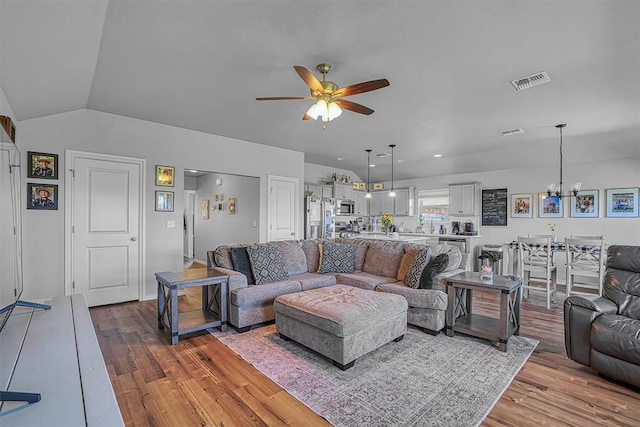 1537 Avalon Dr, Altus, OK 73521 - living area featuring a ceiling fan, wood finished floors, vaulted ceiling, and a chandelier