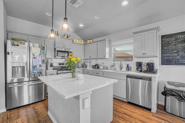 1537 Avalon Dr, Altus, OK 73521 - kitchen featuring stainless steel appliances, a sink, decorative backsplash, light stone countertops, and vaulted ceiling