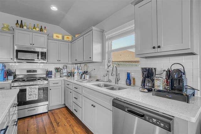 1537 Avalon Dr, Altus, OK 73521 - kitchen featuring appliances with stainless steel finishes, a sink, vaulted ceiling, backsplash, and light stone countertops