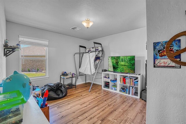 1537 Avalon Dr, Altus, OK 73521 - game room featuring wood finished floors, a textured wall, and baseboards
