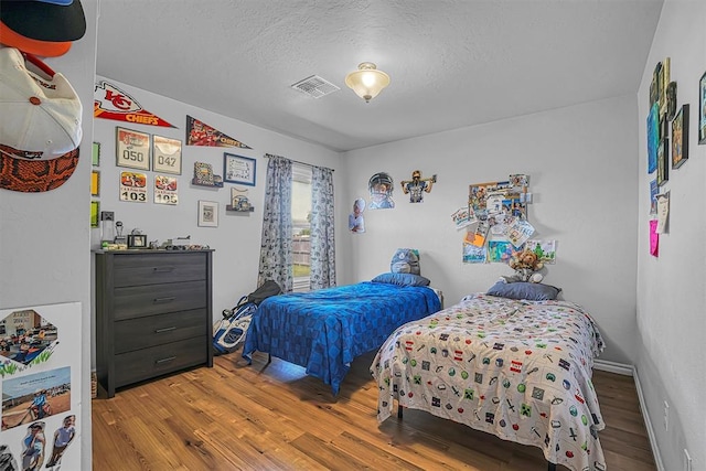 1537 Avalon Dr, Altus, OK 73521 - bedroom with wood finished floors and a textured ceiling