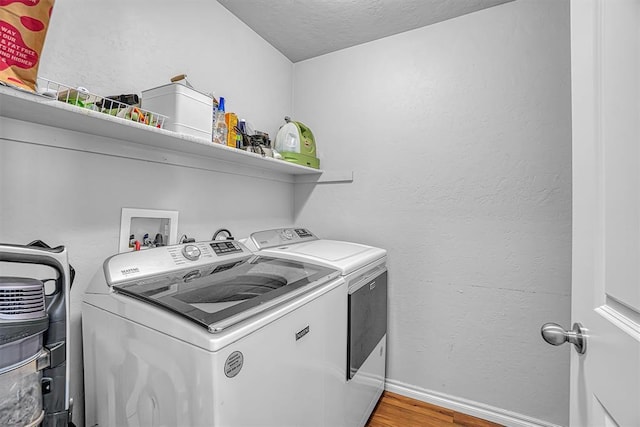 1537 Avalon Dr, Altus, OK 73521 - clothes washing area with washer and dryer, light wood-type flooring, baseboards, and a textured ceiling