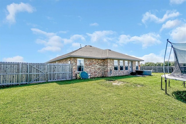 1537 Avalon Dr, Altus, OK 73521 - back of property with a trampoline, brick siding, a gate, and a shingled roof