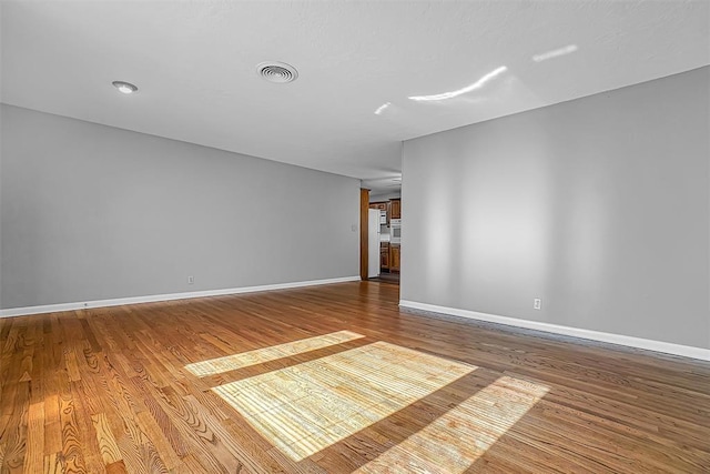 unfurnished room featuring wood finished floors and baseboards