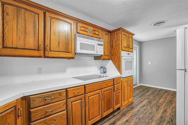 kitchen with white appliances, dark wood-style flooring, brown cabinets, light countertops, and baseboards