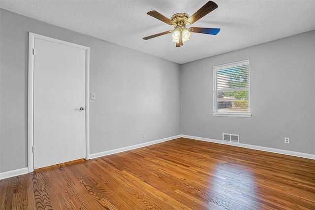 unfurnished room featuring ceiling fan, wood finished floors, and baseboards