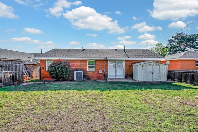 rear view of property featuring a shed, cooling unit, and an outbuilding