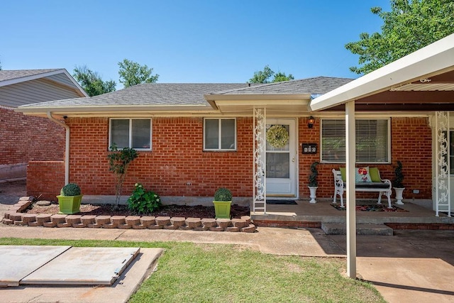 640 SW 1st Pl, Moore, OK 73160 - doorway to property with brick siding, roof with shingles, and a porch