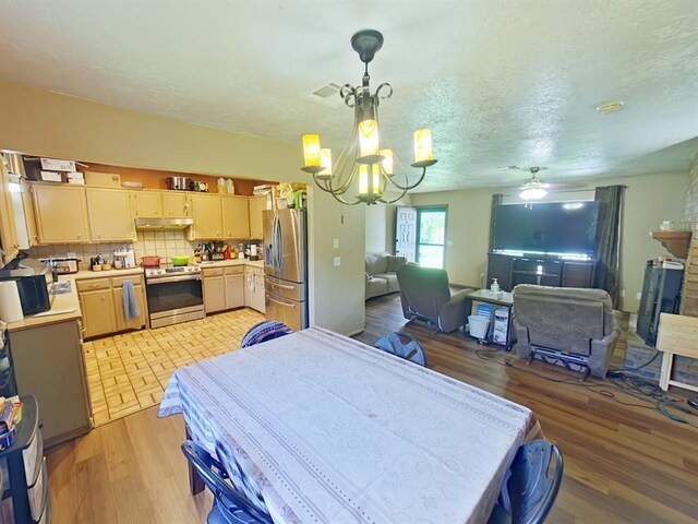 2317 County Road 1268, Blanchard, OK 73010 - dining space featuring a chandelier, light wood finished floors, a ceiling fan, and a textured ceiling