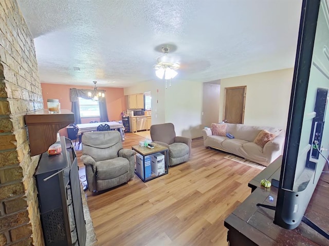 2317 County Road 1268, Blanchard, OK 73010 - living room with light wood-style flooring, a ceiling fan, a textured ceiling, and a chandelier