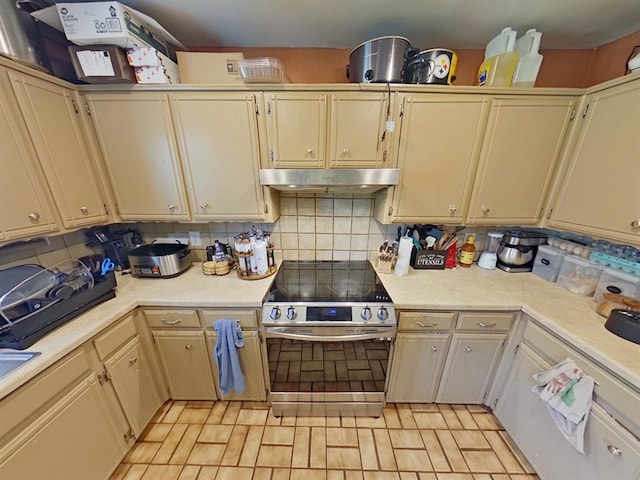 2317 County Road 1268, Blanchard, OK 73010 - kitchen featuring electric stove, under cabinet range hood, light countertops, cream cabinets, and decorative backsplash