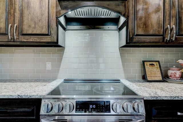 4575 Hidden Path, Kingston, OK 73439 - kitchen featuring stainless steel electric stove, backsplash, dark brown cabinetry, and premium range hood