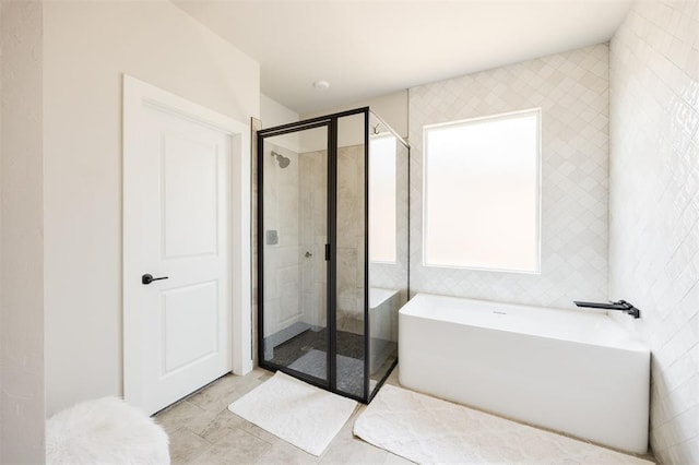 bathroom featuring a shower stall and a freestanding bath