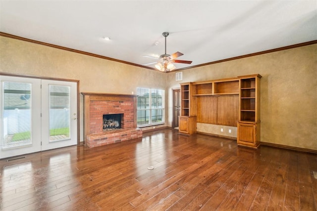 unfurnished living room featuring hardwood / wood-style floors, ceiling fan, crown molding, a brick fireplace, and a textured wall
