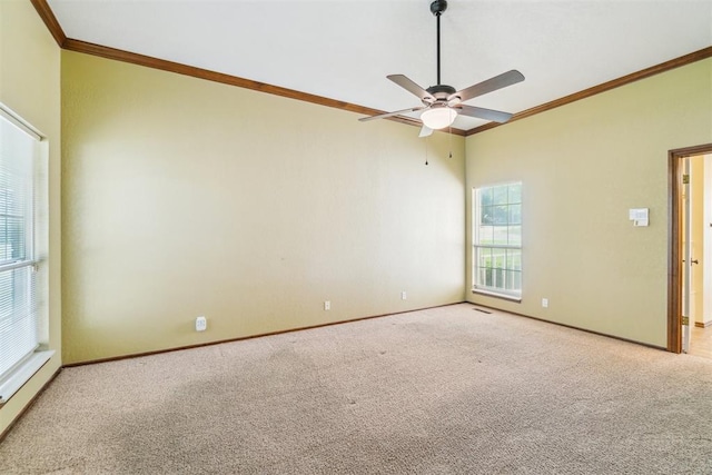 carpeted spare room featuring crown molding, a ceiling fan, and baseboards