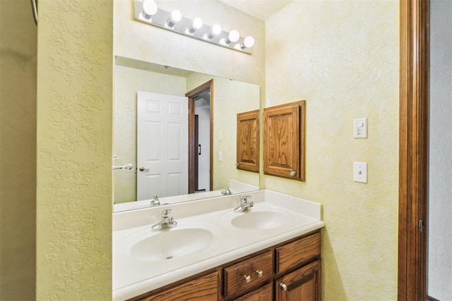 full bath with a textured wall and double vanity
