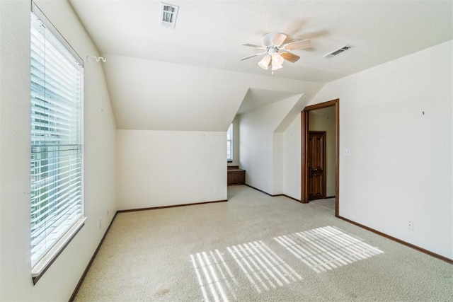 additional living space featuring ceiling fan, light carpet, vaulted ceiling, and baseboards