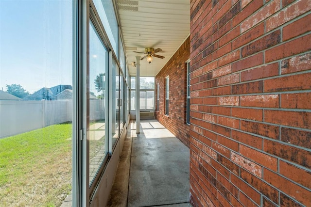 unfurnished sunroom with ceiling fan