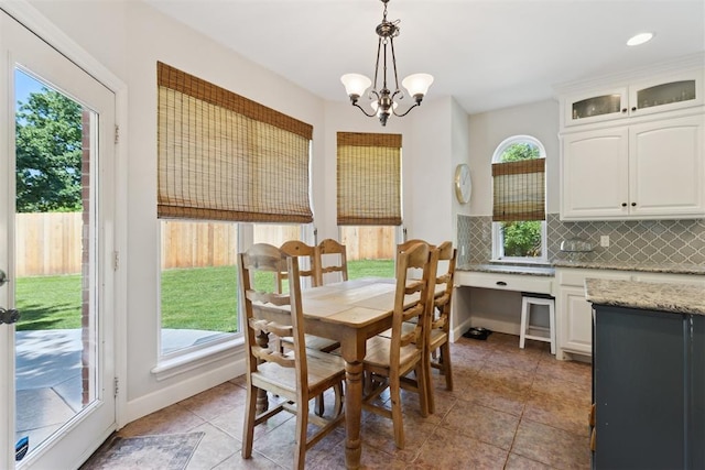dining room featuring a chandelier, light tile patterned floors, and baseboards